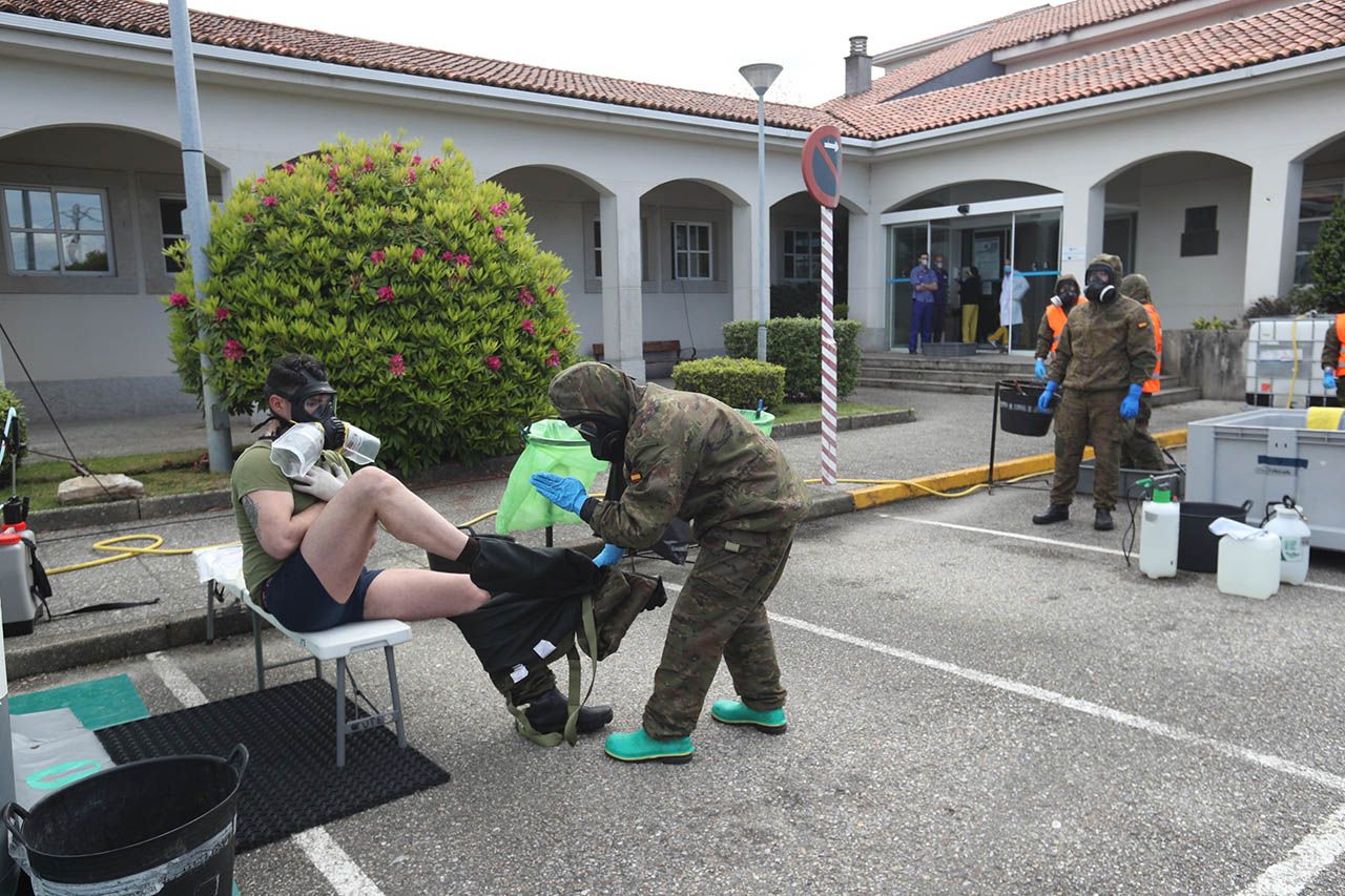 16-abril-Un soldado ayuda a desvestirse a un compañero tras concluir el trabajo ayer en Redondela Grobas.jpg