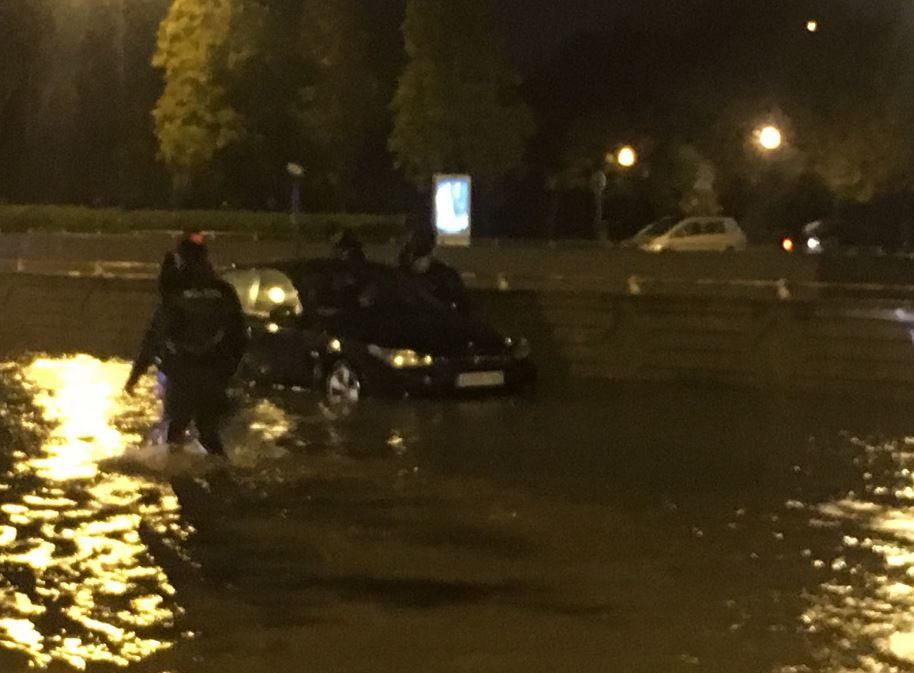 Agentes del Cuerpo Nacional de Policía ayudan a los coches parados por la lluvia en Valencia, anoche.