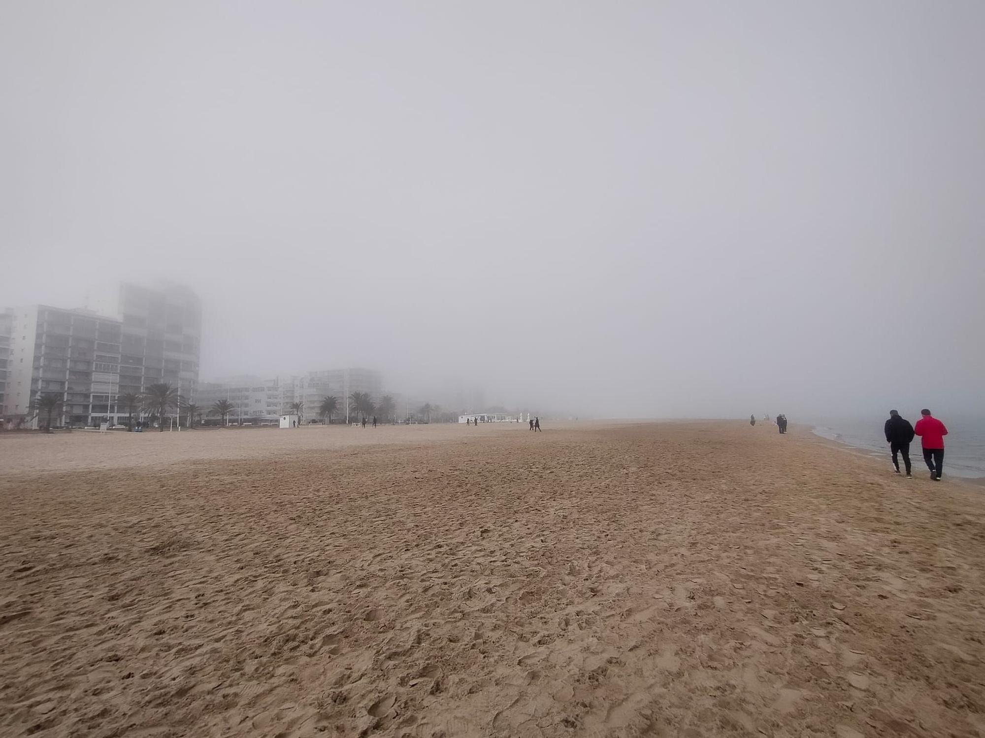 La playa de Gandia desaparece entre la niebla