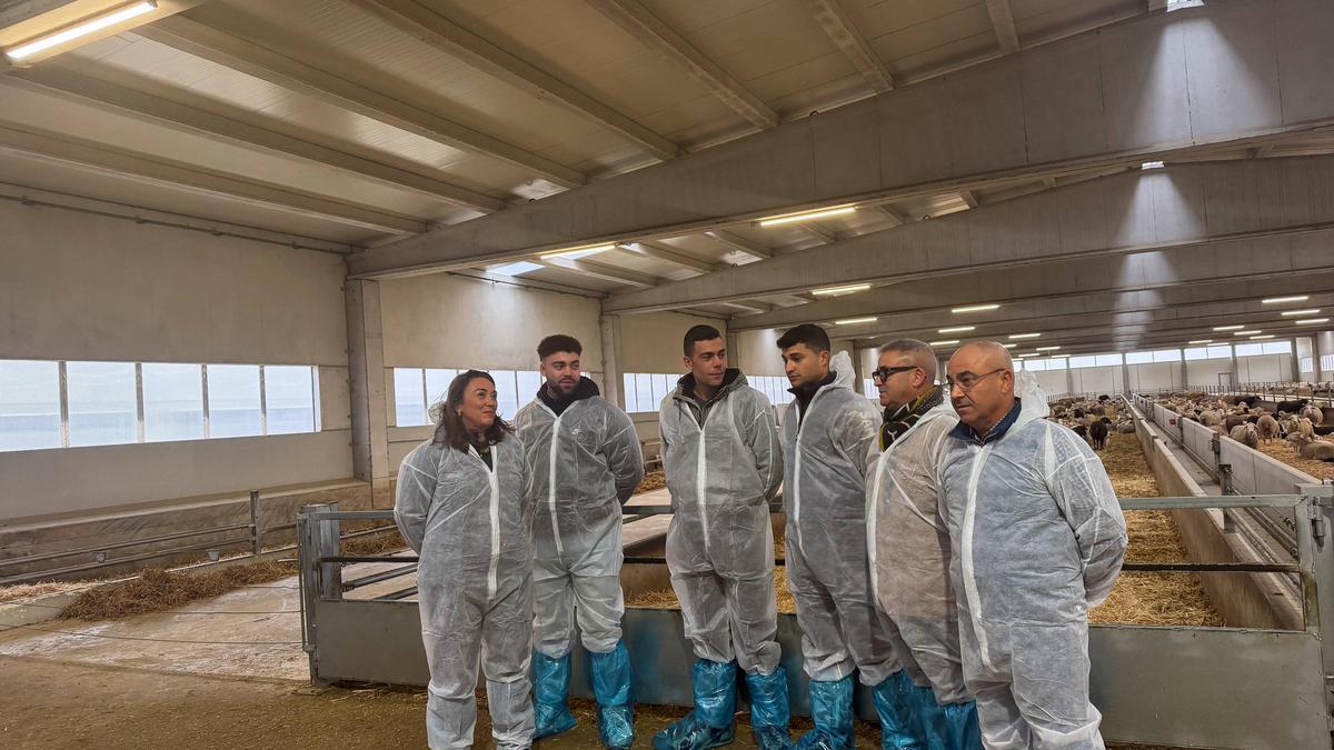 La consejera posa con los tres jóvenes que se han incorporado al sector y dos responsables de la granja.