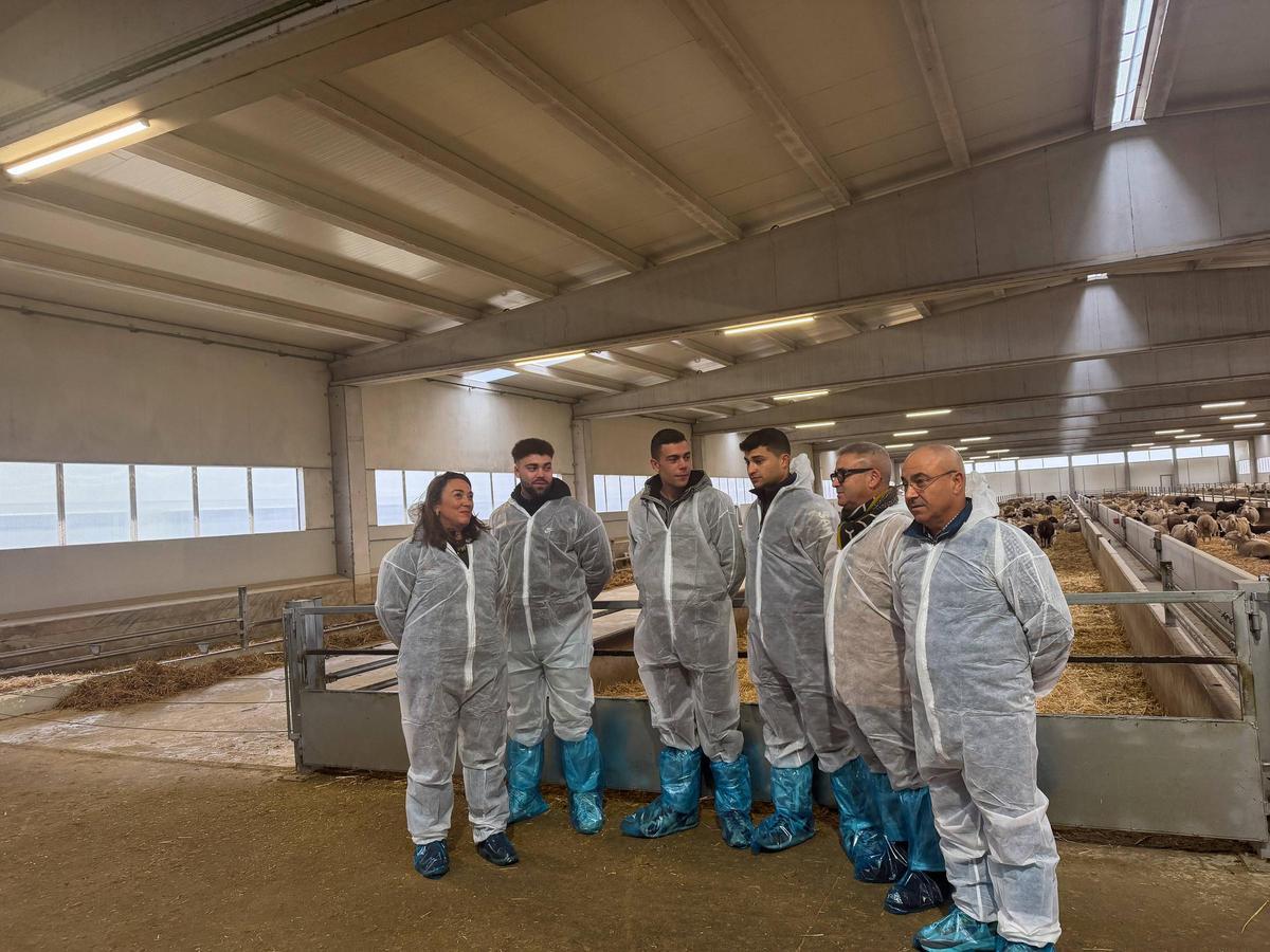 La consejera posa con los tres jóvenes que se han incorporado al sector y dos responsables de la granja.