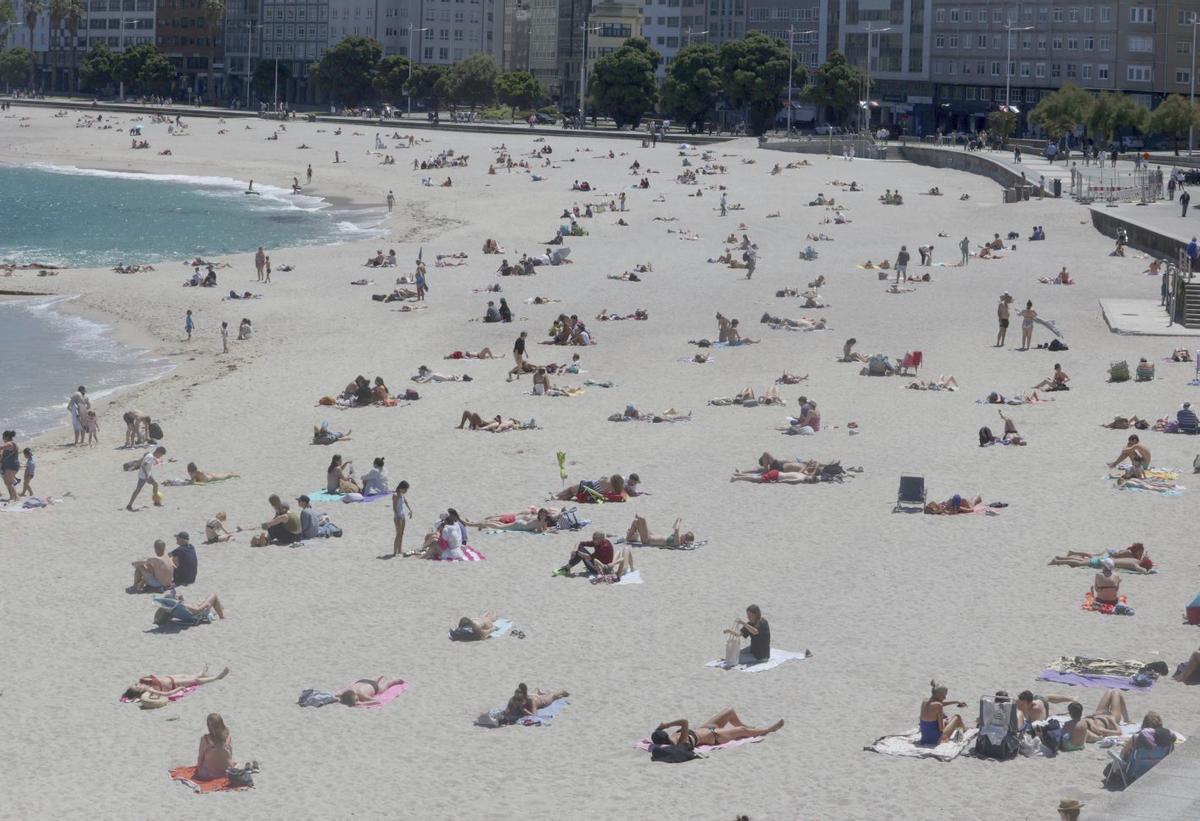 Bañistas y turistas en la playa de Riazor. | Iago López |