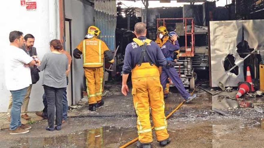 Los bomberos ultiman los trabajos de control mientras los afectados esperan junto a la nave.