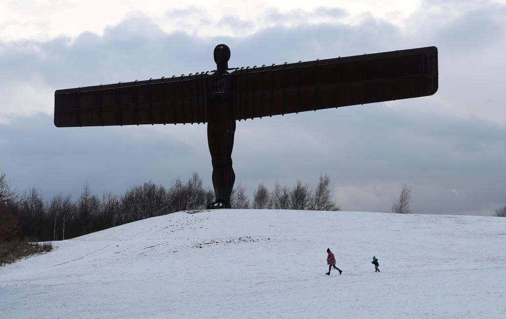 People play near the Angel of North statue ...