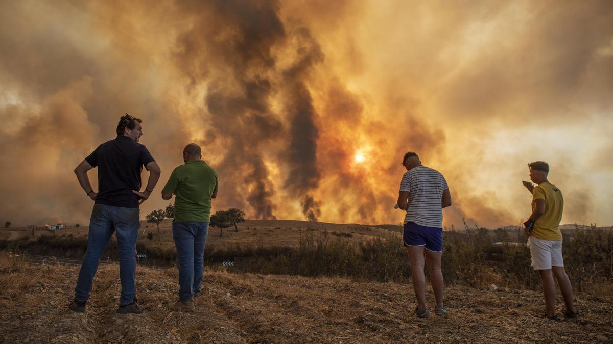 Vecinos contemplan el incendio de Almonaster en una imagen de archivo.