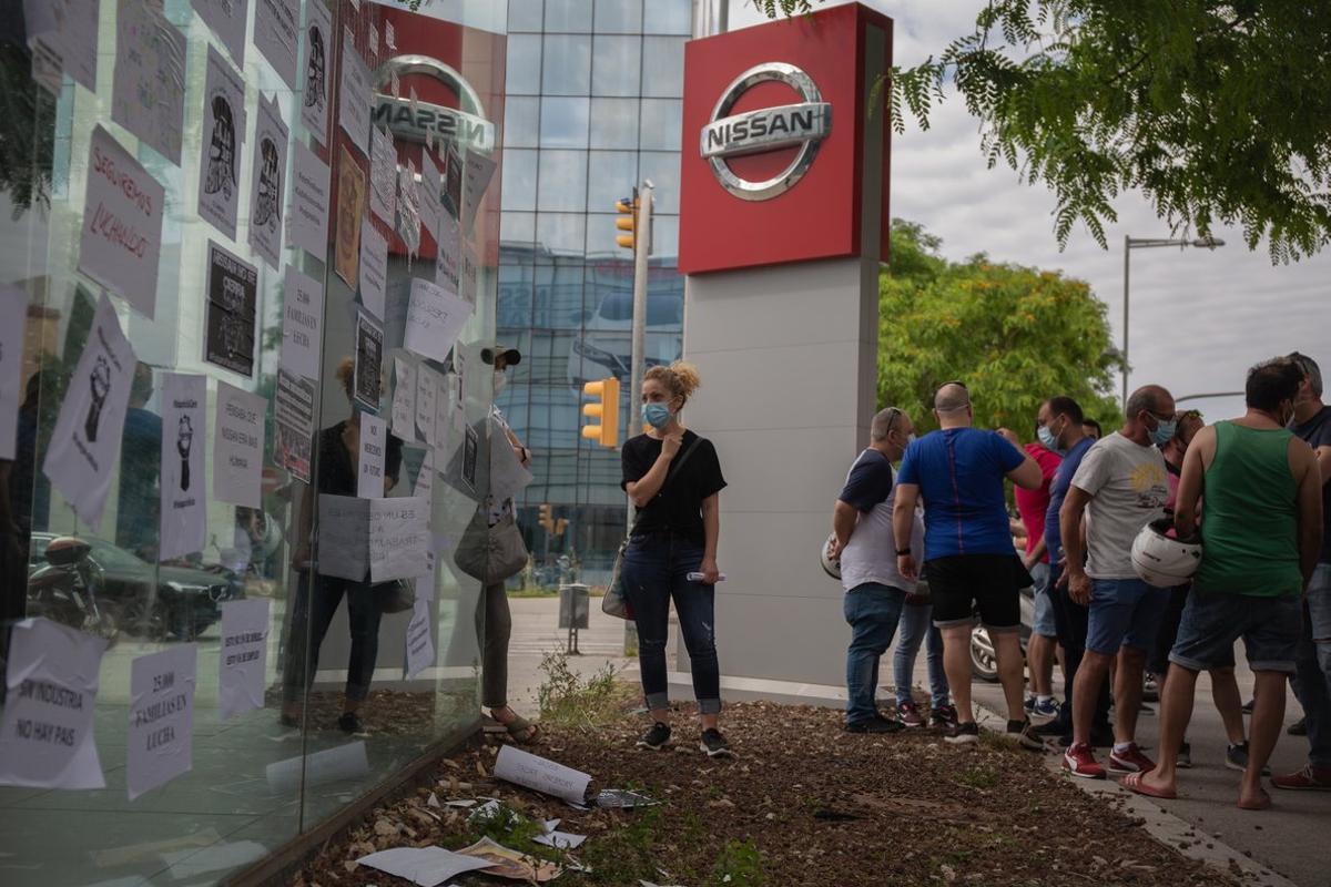 Trabajadores de Nissan cuelgan carteles como signo de protesta en el corte que han realizado en la Gran VÃ­a de LâHospital (Barcelona), cerca del concesionario de Nissan Motor LlansÃ , uno de los cuatro concesionarios donde los comitÃ©s de empresa del fabricante japonÃ©s de automÃ³viles ha convocado concentraciones por el cierre de la planta en la Zona Franca anunciado ayer por la empresa, que supondrÃ¡ el recorte de los cerca de 3.000 puestos de trabajo directos. En Barcelona, Catalunya (EspaÃ±a), a 29 de mayo de 2020.