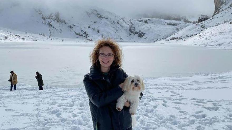 Vanessa Gutiérrez, con su perro Chicu y, al fondo, en lago de La Ercina, totalmente helado