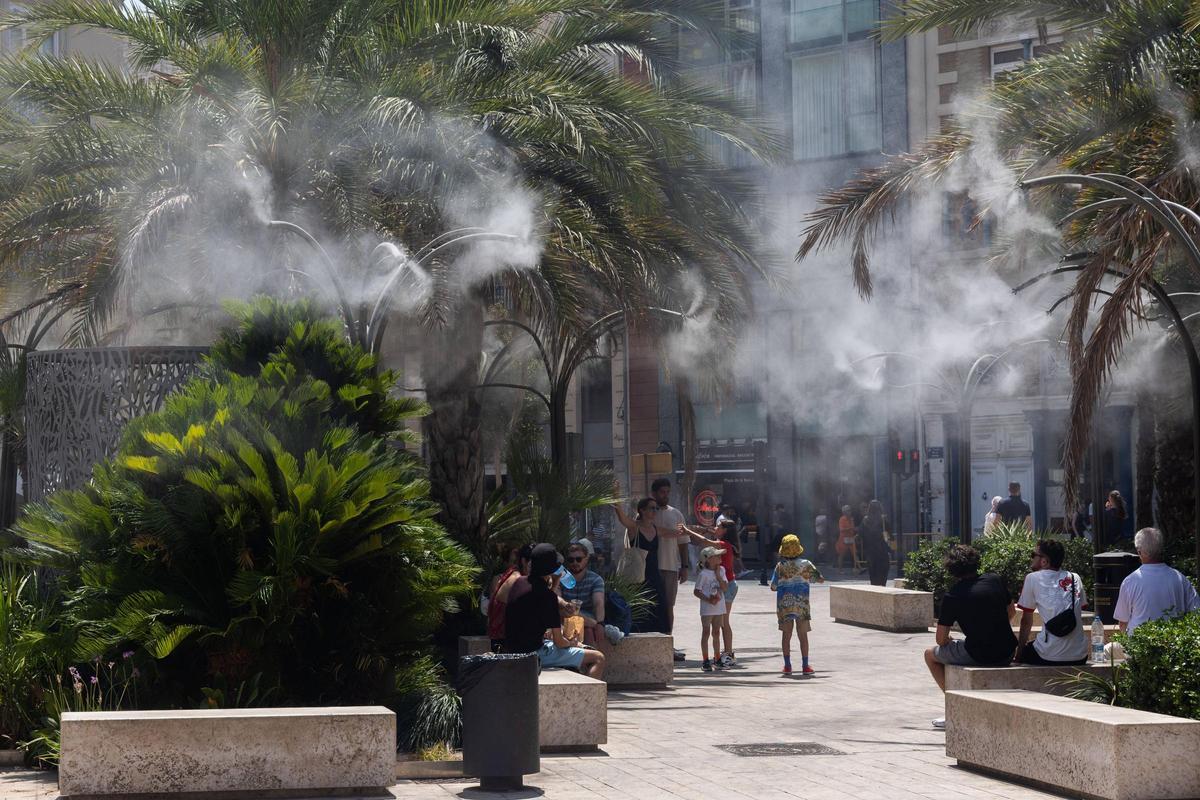 Aspersores de agua ayer a pleno rendimiento en el refugio climático de la Plaza de la Reina de València.