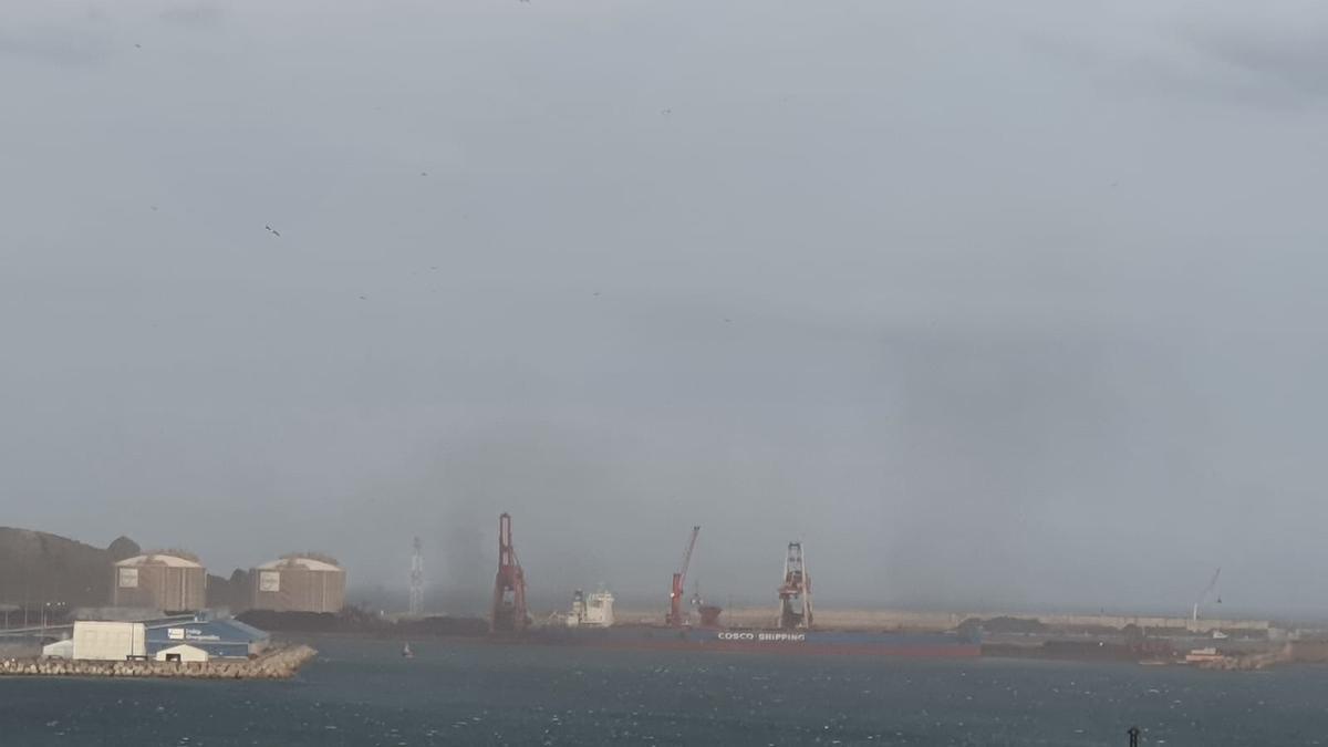 Imagen de la nube de carbón de esta mañana, al fondo, vista desde el centro de Gijón.