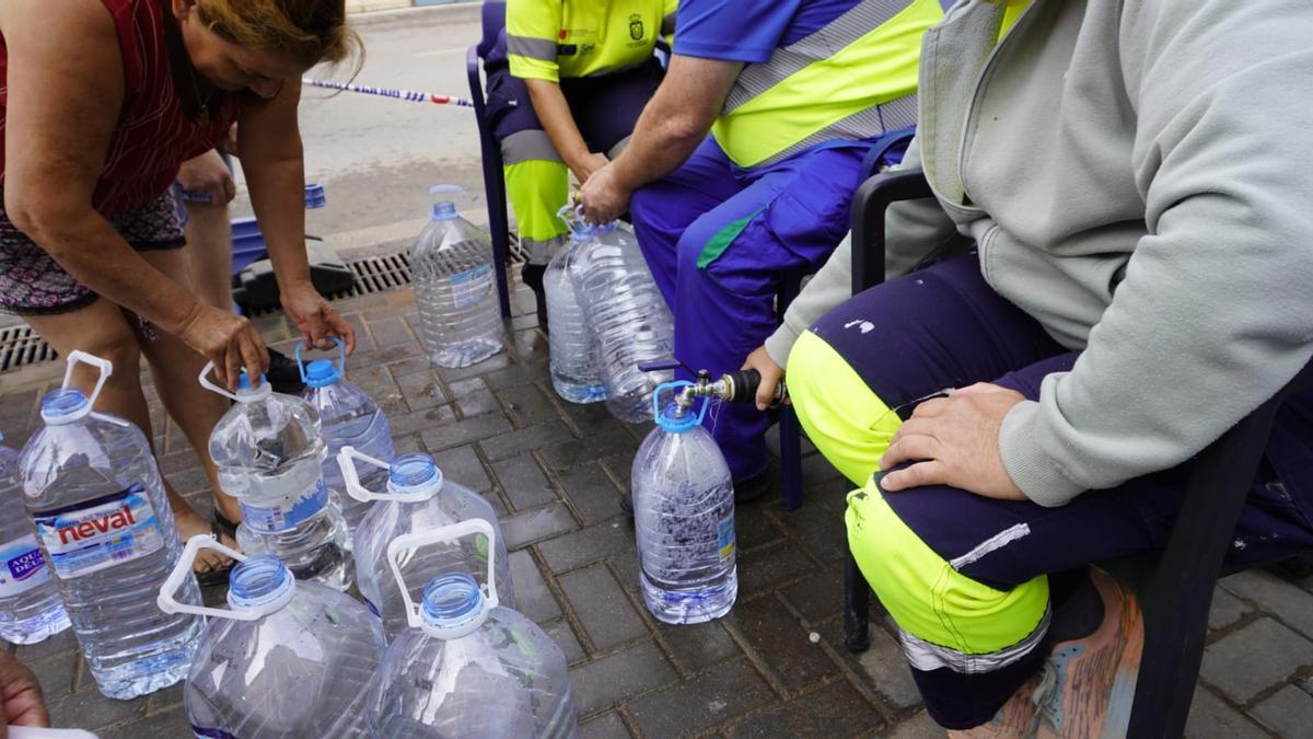 Vecinos de Los Alcázares rellenan garrafas de agua en las cubas móviles durante las semanas sin suministro.
