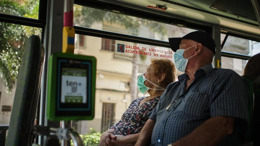 Dos tinerfeños, en una guagua de Titsa.