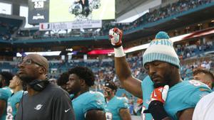 Miami Dolphins defensive end Robert Quinn (94) raises his right fist during the singing of the national anthem, before the team’s NFL preseason football game against the Tampa Bay Buccaneers, Thursday, Aug. 9, 2018, in Miami Gardens, Fla. (AP Photo/Wilfredo Lee)