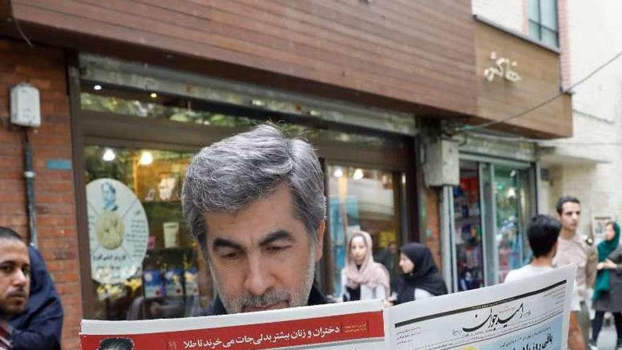 Un iraní lee en un periódico la noticia de la decisión de Trump. // Reuters