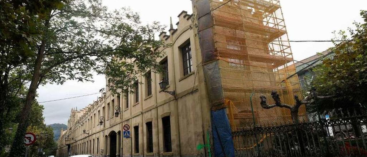 El edificio de acceso a la fábrica de armas, con un andamio en uno de sus laterales.