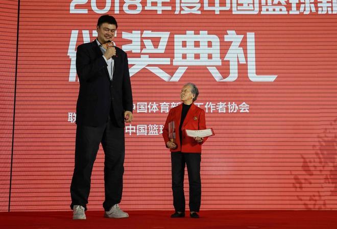 Foto tomada el 24 de abril de 2019 muestra a la ex estrella de baloncesto de la NBA Yao Ming (L) hablando con Hong Nanli, una fotógrafa deportiva de 81 años.