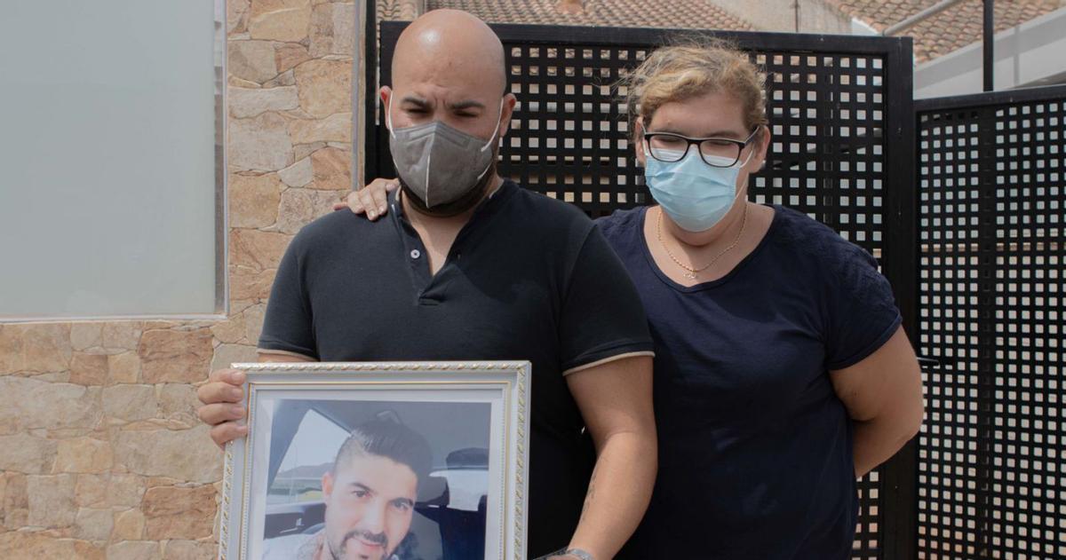 Familiares del hombre asesinato en La Puebla en 2021 muestran su fotografía. | LOYOLA PÉREZ DE VILLEGAS