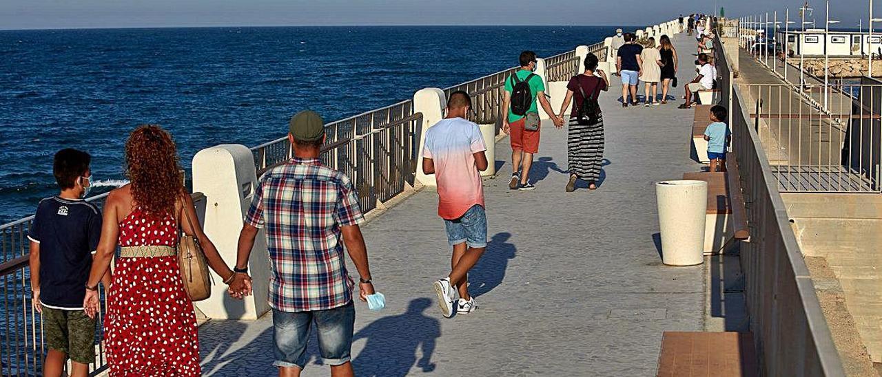 Un grupo de personas por el paseo de la Escollera de la playa el pasado julio.