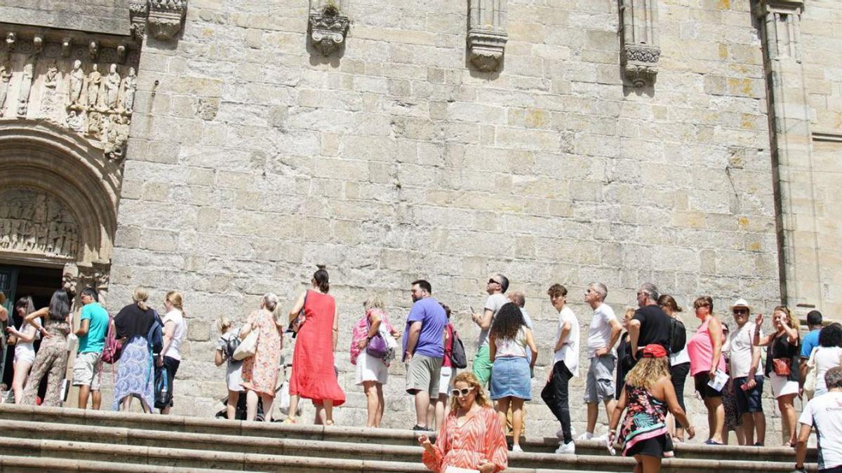Pese al intenso calor, turistas y peregrinos aguardan para acceder a la Catedral de Santiago