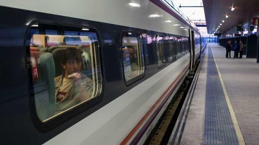 Un viajero mira por ventana desde su asiento del tren.