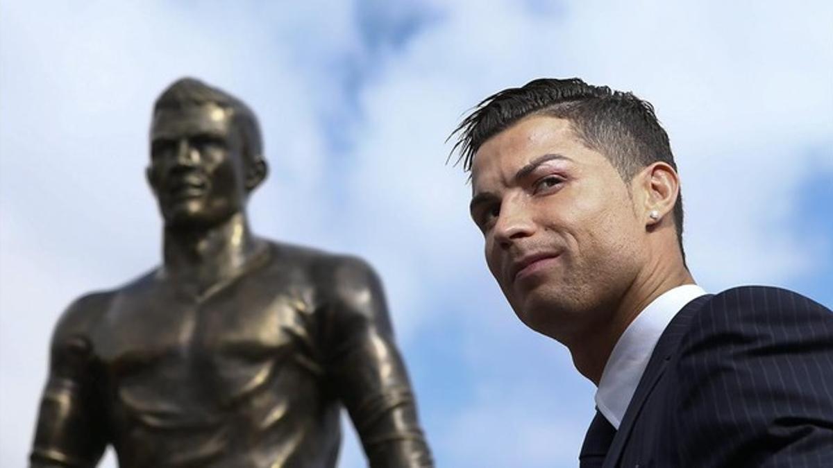 Cristiano Ronaldo posa junto a su estatua em Funchal.