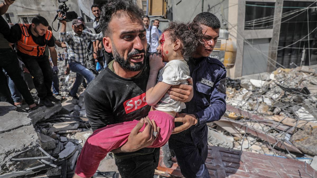 Un home carrega una nena ferida a Gaza
