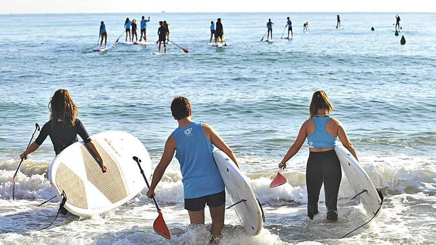 Niños practicando paddle surf.