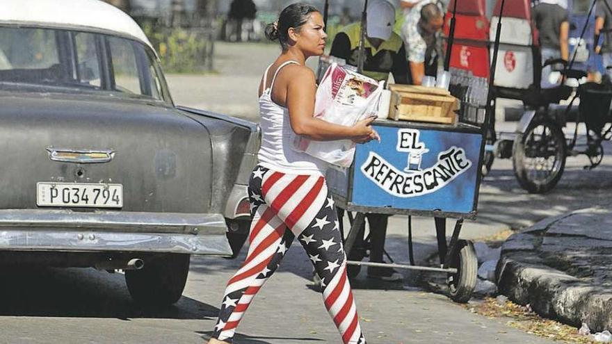 Una joven cubana camina por La Habana con un pantalón que remeda la bandera de EE UU. // Efe