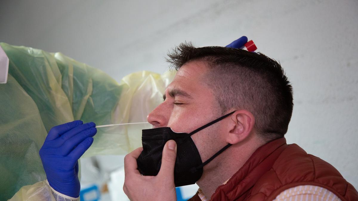 Un sanitario, realizando un PCR a un ciudadano.