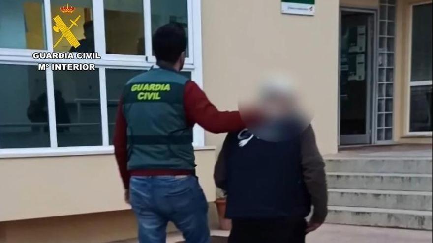 Un guardia civil conduce al presunto pirómano detenido.