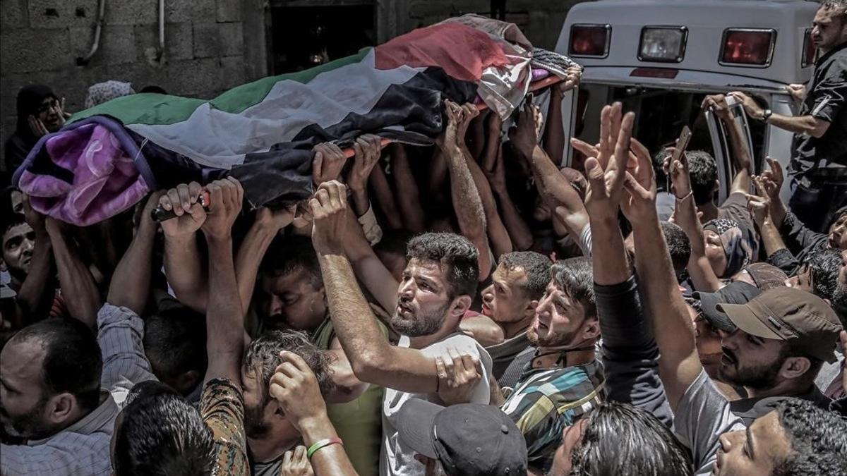 La muchedumbre traslada el féretro de Razan Najjar, la enfermera que ha muerto por los disparos hebreos.