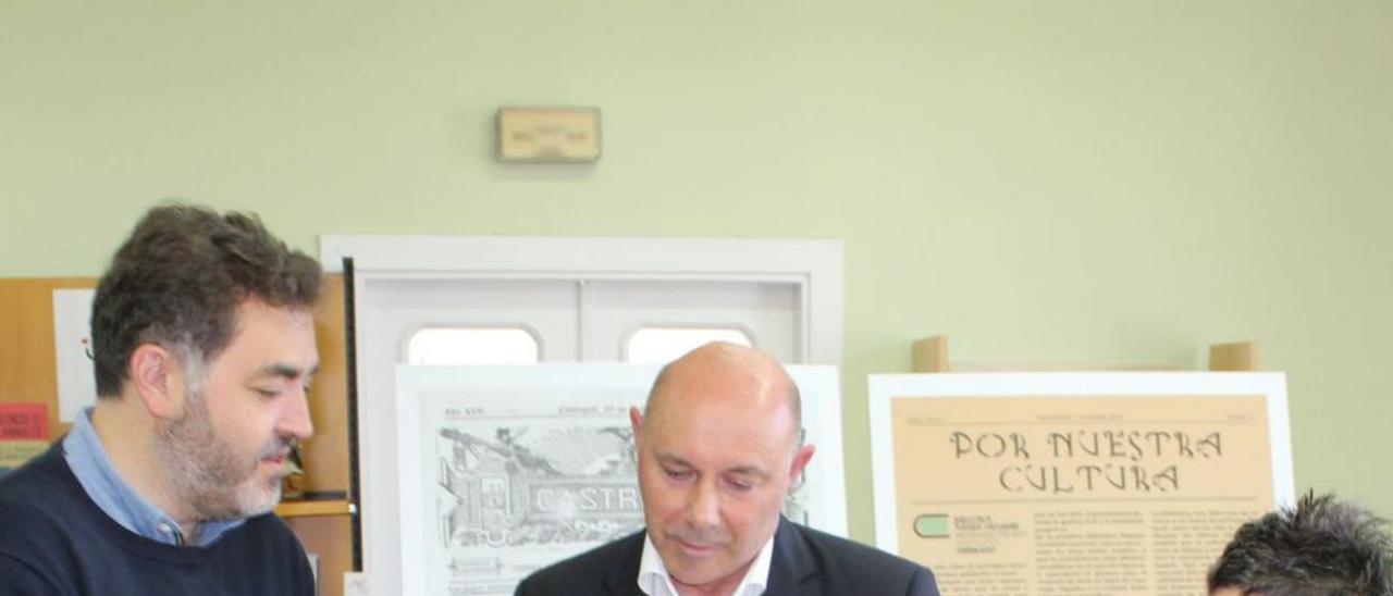 Fernández entrega las firmas al alcalde de Castropol, Francisco Javier Vinjoy, en presencia de la bibliotecaria Manuela Busto. | T. Cascudo