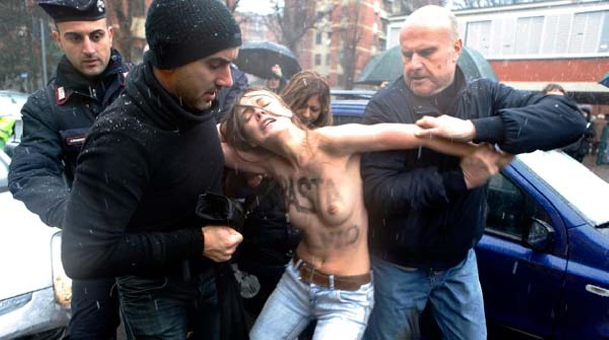 Tres jovenes desnudas protestan ante Berlusconi cuando intenta votar.