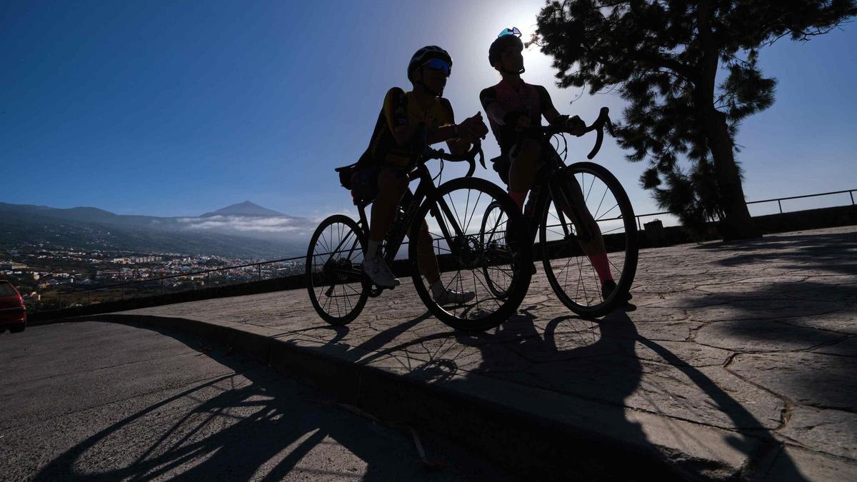 Dos ciclistas, con el Teide al fondo.
