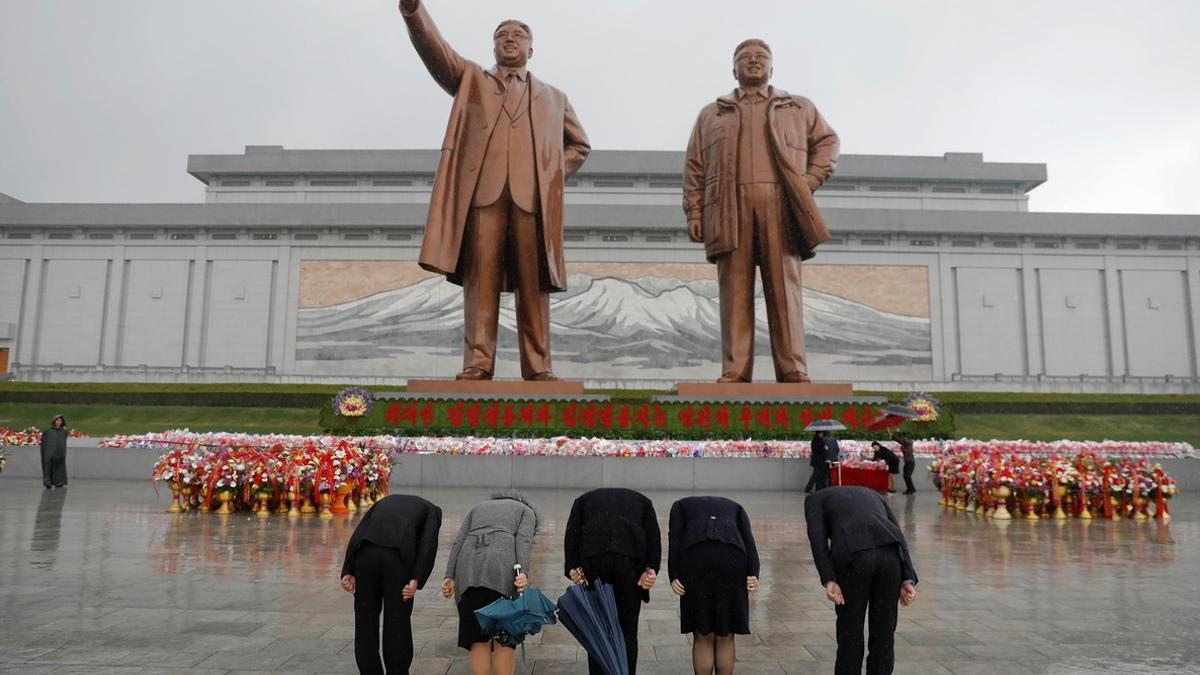 Norcoreanos muestran su respeto ante las estatuas de los líderes del país en Pyongyang.
