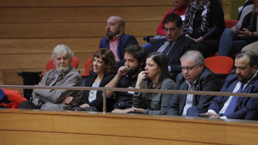 Cuiña (derecha)  observa su teléfono en una sesión del Parlamento de Galicia.