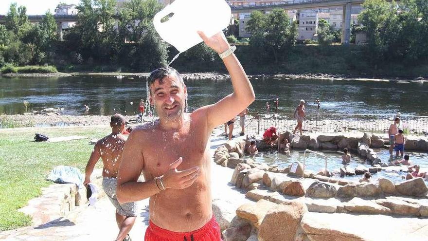 Un bañista de las termas se refresca con una garrafa de agua.  // Iñaki Osorio