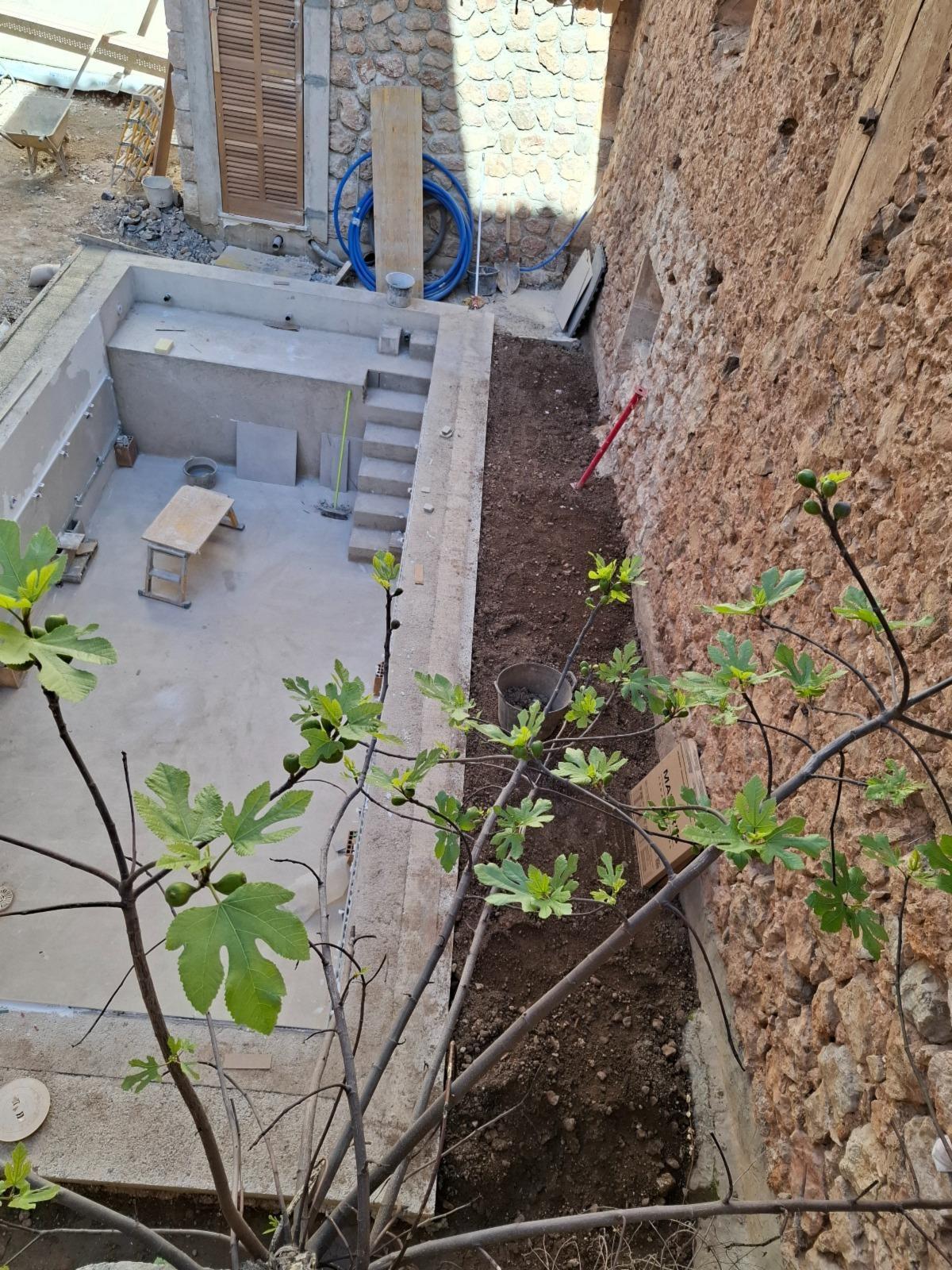 Obras de construcción de la pileta. A la derecha, el muro de la iglesia.
