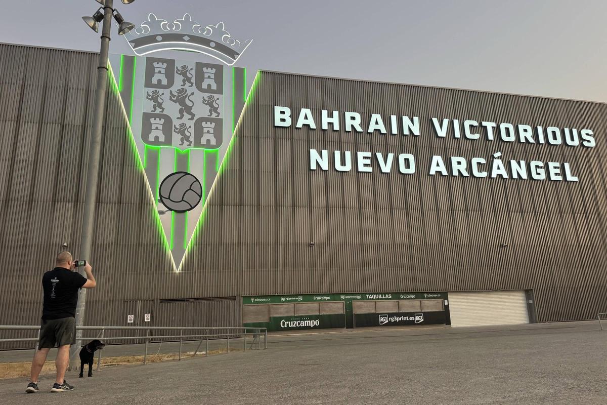 Un aficionado fotografía el nuevo letrero del Bahrain Victorious Nuevo Arcángel iluminado.