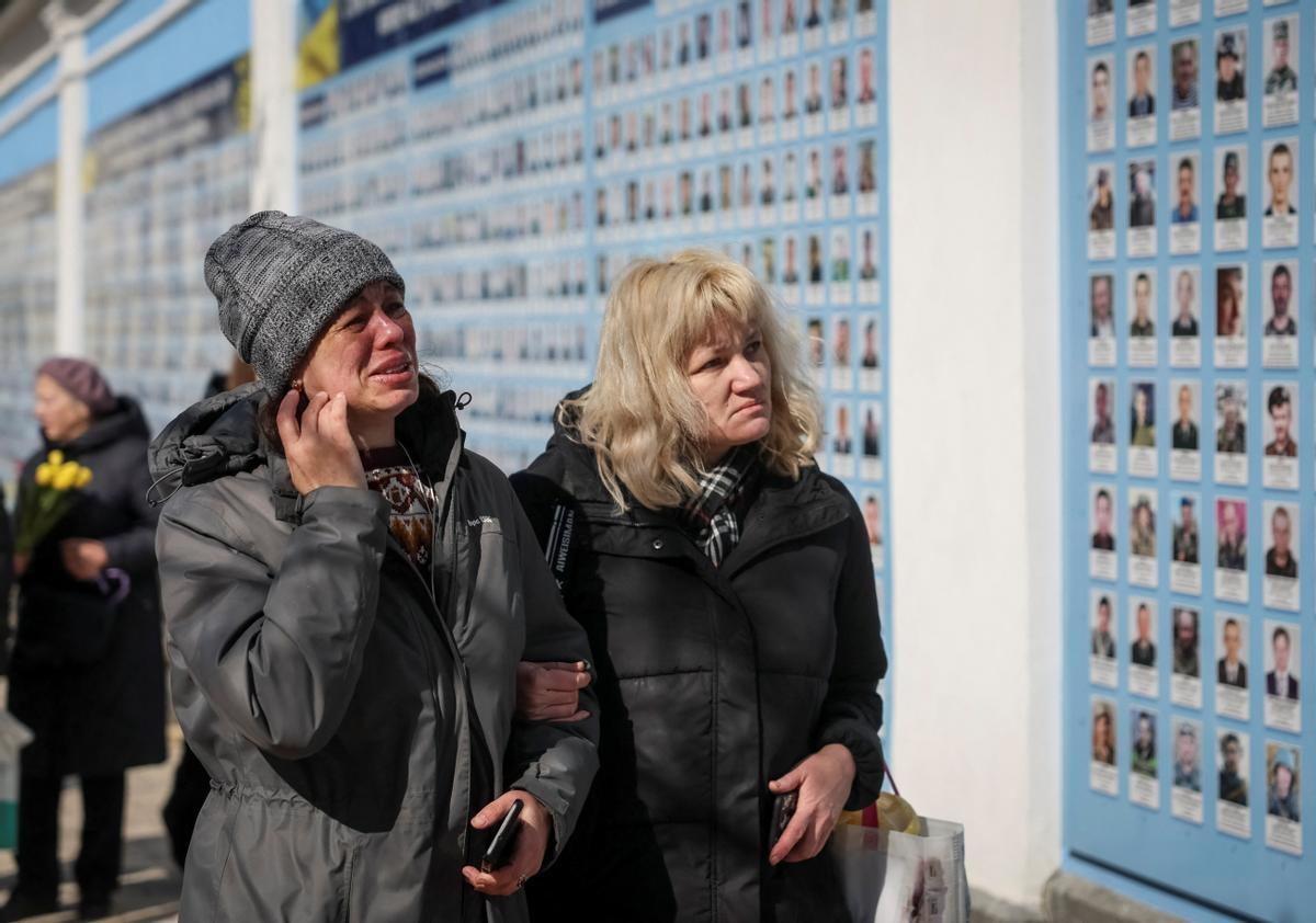 La gente visita el Muro del Recuerdo para conmemorar el Día de los Voluntarios en honor a los combatientes muertos que se unieron a las fuerzas armadas ucranianas.