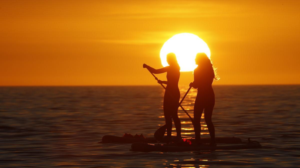 Dos adolescentes practican paddle surf en Portosín.