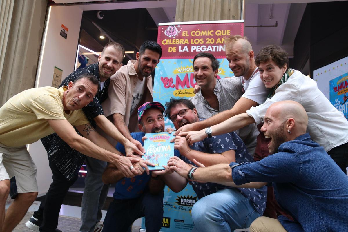 Los miembros de La Pegatina rodean al dibujante Mr. Ed y al guionista Lluc Silvestre (derecha), mordiendo el cómic del aniversario. Los miembros de La Pegatina rodean al dibujante Mr. Ed y al guionista Lluc Silvestre (derecha), mordiendo el cómic del aniversario.