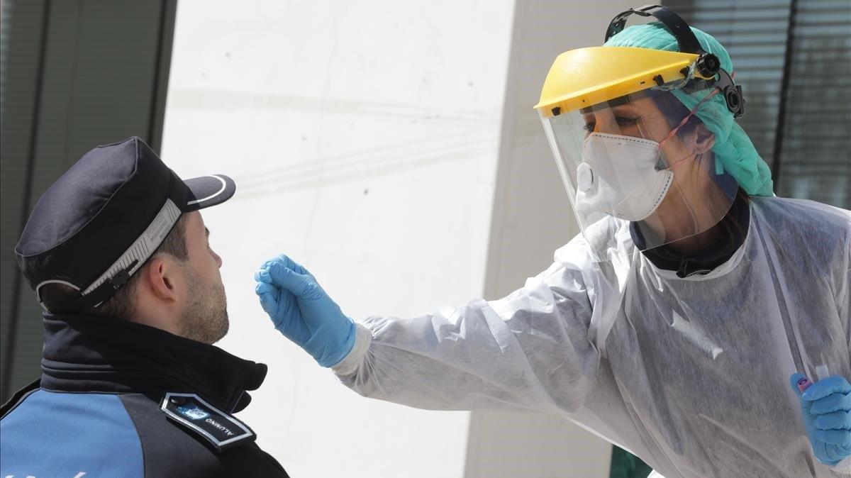 Personal sanitario realiza una prueba a un policía municipal de Madrid.