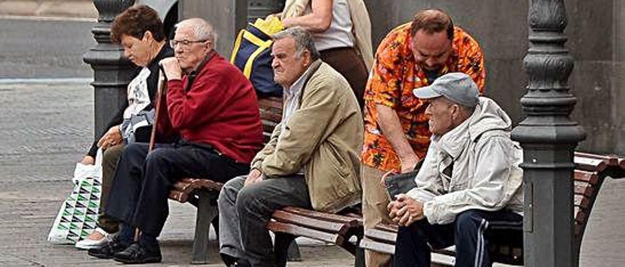 Un grupo de jubilados sentados en un banco de la capital grancanaria.