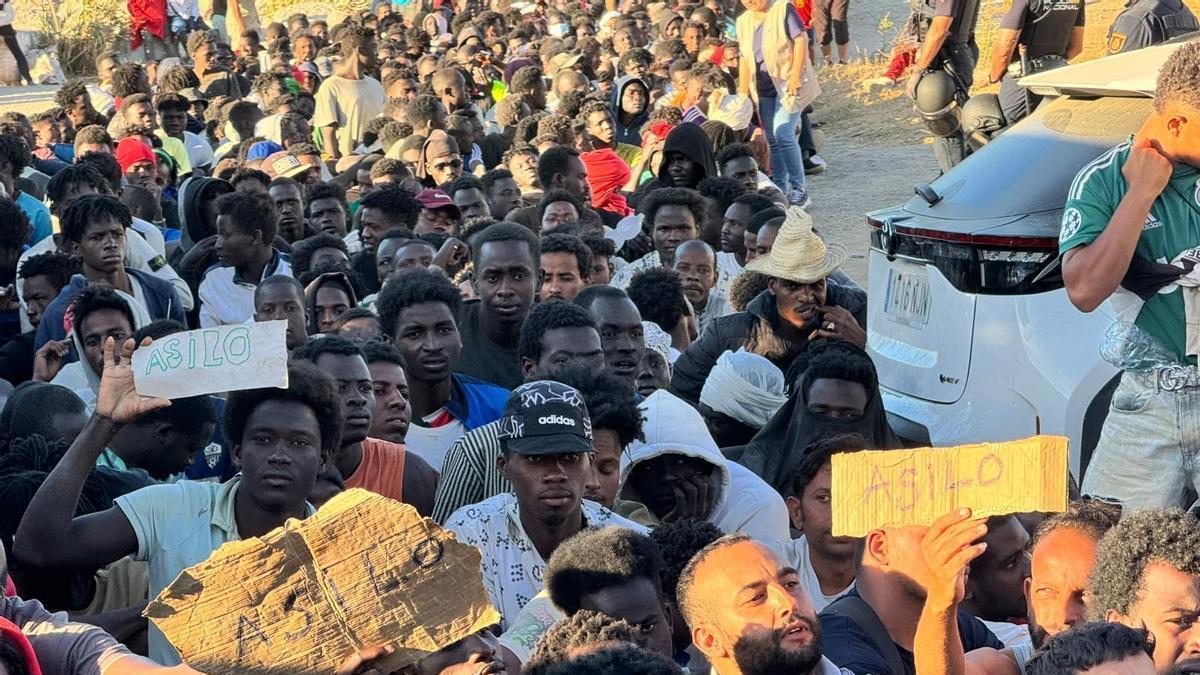 Una multitud de personas migrantes en el reparto de alimentos de Cruz Roja y la organización Sur Sur, en Ceuta.