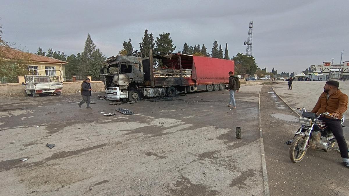 Varios viandantes inspeccionan en el distrito turco de Karkamis un camión alcanzado por varios misiles lanzados desde el norte de Siria.
