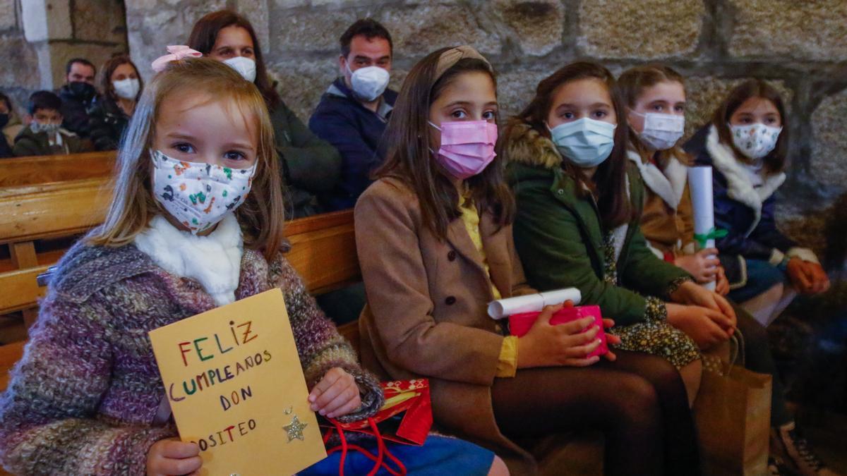 Una niña sostiene una tarjeta de felicitación que minutos después entregaría al sacerdote