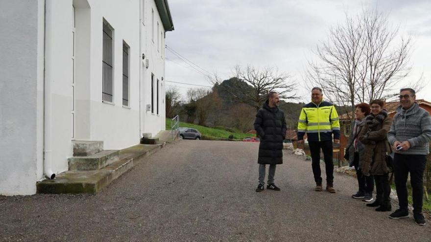 Por la izquierda, Ángel García, Alejandro Villa, dos vecinas y Pergentino Martínez, ayer, frente a las escuelas de Vega de Poja. | L. Rodríguez