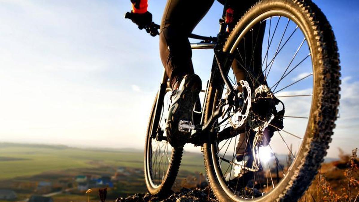 Imagen de una persona montando una bicileta de montaña o BTT.