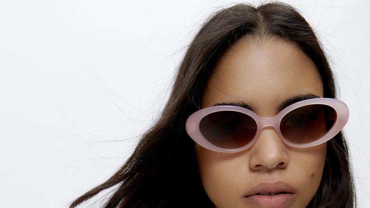 Modelo de Uterqüe con gafas de sol rosadas y camisa a cuadros de colores