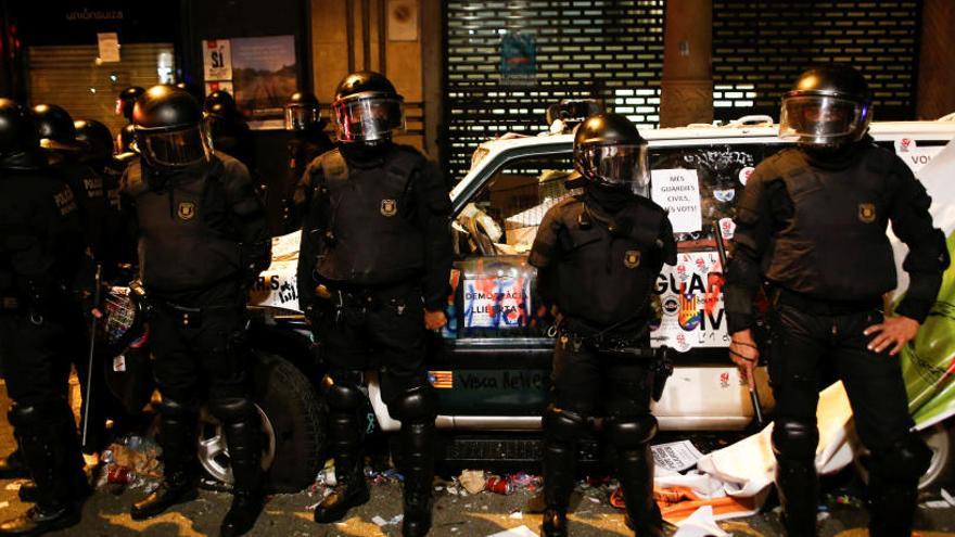 Mossos davant d&#039;un cotxe de la Guàrdia Civil, a Barcelona.